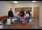 Michele Hamilton, right, is the head elf for the Christmas For Kids program in Sparta, which provides present for children in low-income families. She and helper Cathy Abbott, second from left, helped Josh Lydon and DeDe Mack from 1st Community Credit Union unload presents at the Dodge & Davis building in downtown Sparta last Friday. Herald photo by Pat Mulvaney